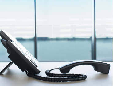 Telefon steht am Tisch, der Hörer liegt daneben.